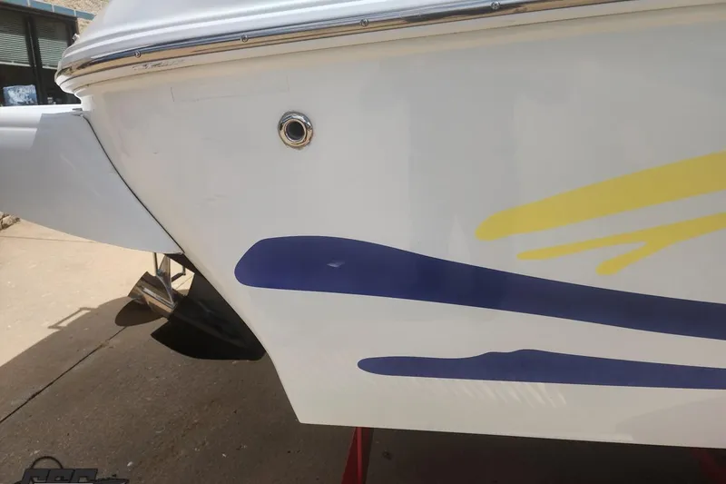 Slide: The Image of 2005 Baja 242 Islander boat with colorful hull design, docked on concrete surface. - 18