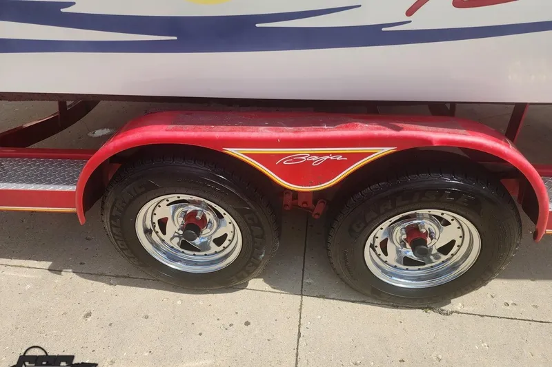 Slide: The Image of Red trailer with Baja branding, featuring dual wheels for a 2005 Baja 242 Islander boat. - 20