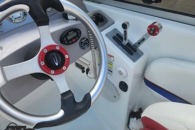 Slide: The Image of 2005 Baja 242 Islander boat cockpit with steering wheel and control levers. - 29