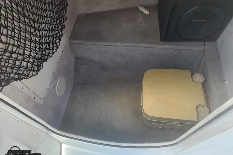 Slide: The Image of 2005 Baja 242 Islander boat interior with portable toilet and speaker. - 39