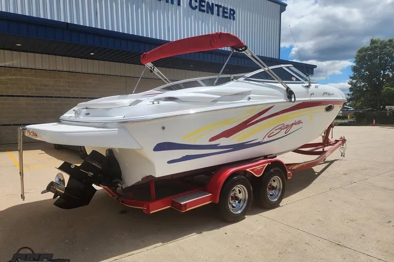 Slide: The Image of 2005 Baja 242 Islander boat on red trailer, parked outside a service center. - 4
