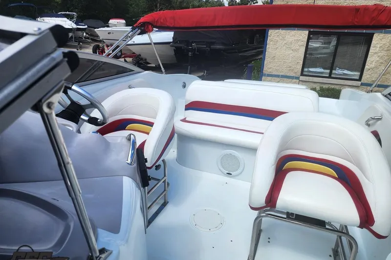 Slide: The Image of 2005 Baja 242 Islander boat interior with colorful seating and red canopy. - 49