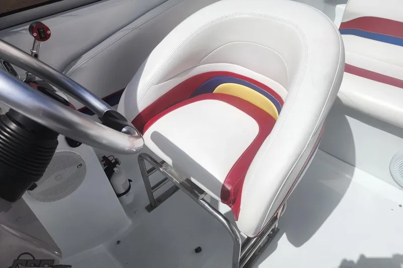 Slide: The Image of 2005 Baja 242 Islander boat interior with colorful seating and steering wheel. - 51