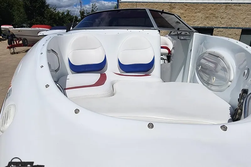 Slide: The Image of 2005 Baja 242 Islander boat with white and blue seating, docked outdoors. - 6