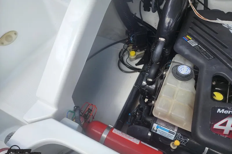 Slide: The Image of Engine compartment of a 2005 Baja 242 Islander boat with visible components and fire extinguisher. - 62