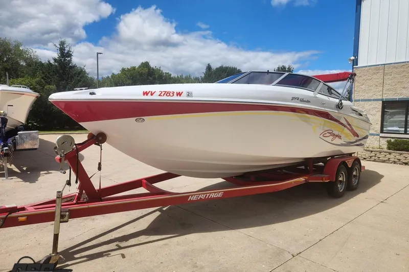Slide: The Image of 2005 Baja 242 Islander boat on red trailer, parked outdoors under blue sky. - 7