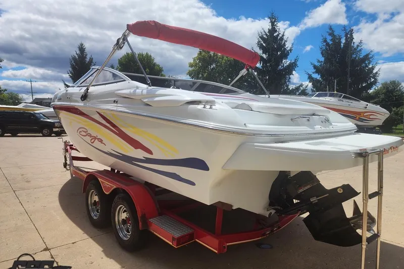 Slide: The Image of 2005 Baja 242 Islander boat on trailer, featuring colorful graphics and red canopy. - 9