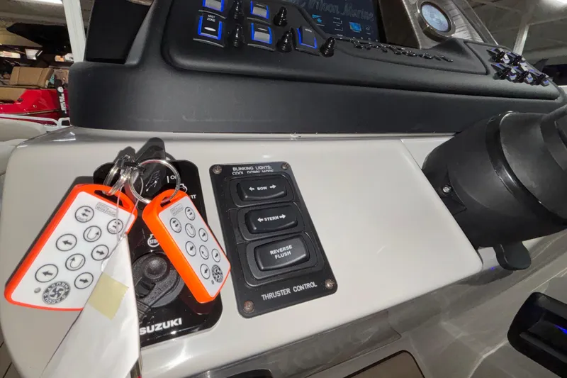 Slide: The Image of Control panel of 2026 JC Sporttoon 26TT boat with key fobs and thruster controls. - 38