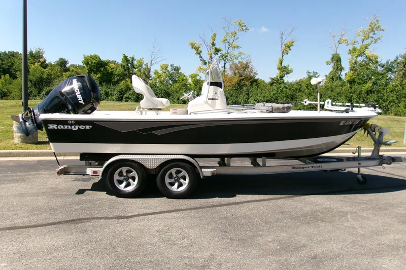 The Image of 2015 Ranger 220 Bahia boat on trailer, parked outdoors, with Mercury engine. - 0