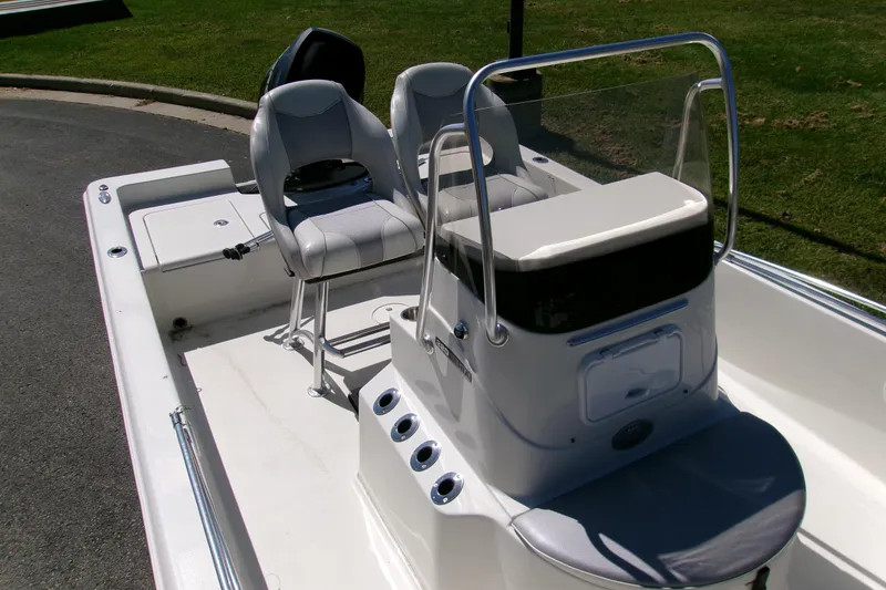 Slide: The Image of 2015 Ranger 220 Bahia boat interior with seating and console, parked on pavement. - 4