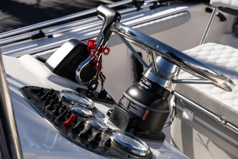 Slide: The Image of Steering console of 2026 Carolina Skiff 21 LS boat with chrome details and controls. - 14