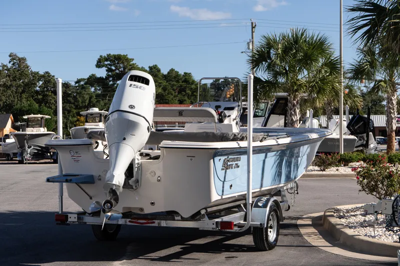 Slide: The Image of 2026 Carolina Skiff 21 LS boat on trailer, parked outdoors with palm trees. - 6