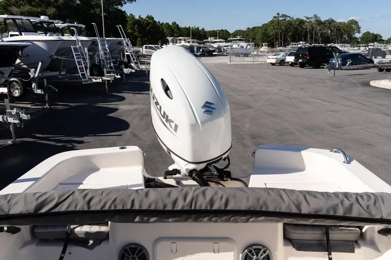 Slide: The Image of 2026 Carolina Skiff 21 LS with Suzuki outboard motor in a boat dealership. - 9