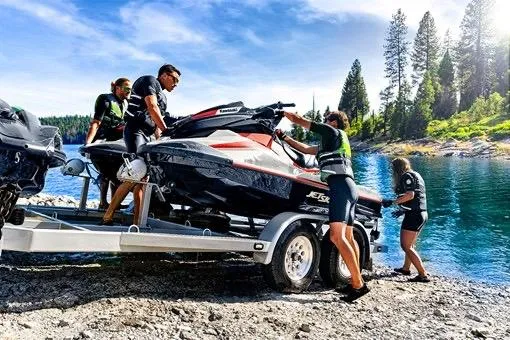 Slide: The Image of People unloading a 2025 Kawasaki JET SKI STX 160X by a scenic lake. - 6