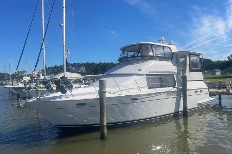 Slide: The Image of 2000 Carver 456 Aft Cabin Motor Yacht docked in a marina under clear blue skies. - 0