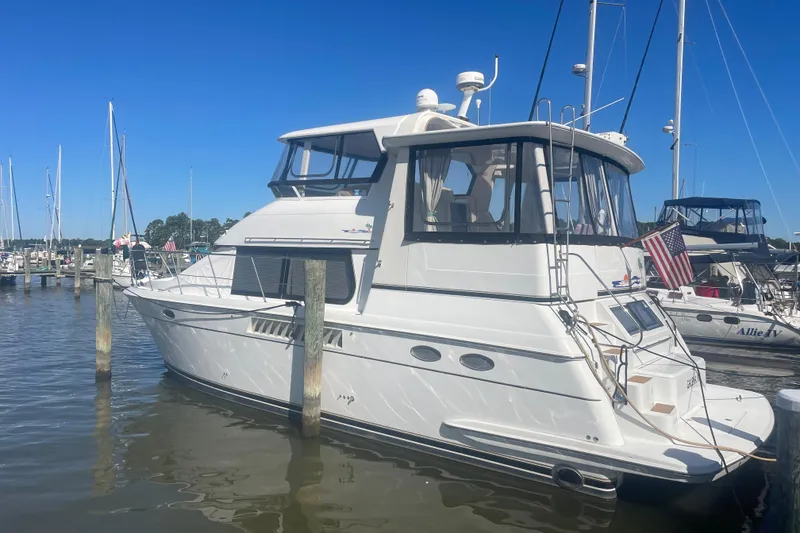 Slide: The Image of 2000 Carver 456 Aft Cabin Motor Yacht docked in a marina under clear blue skies. - 1