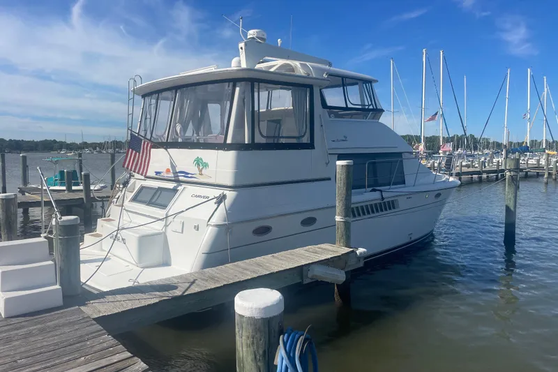 Slide: The Image of 2000 Carver 456 Aft Cabin Motor Yacht docked at marina under clear blue sky. - 2