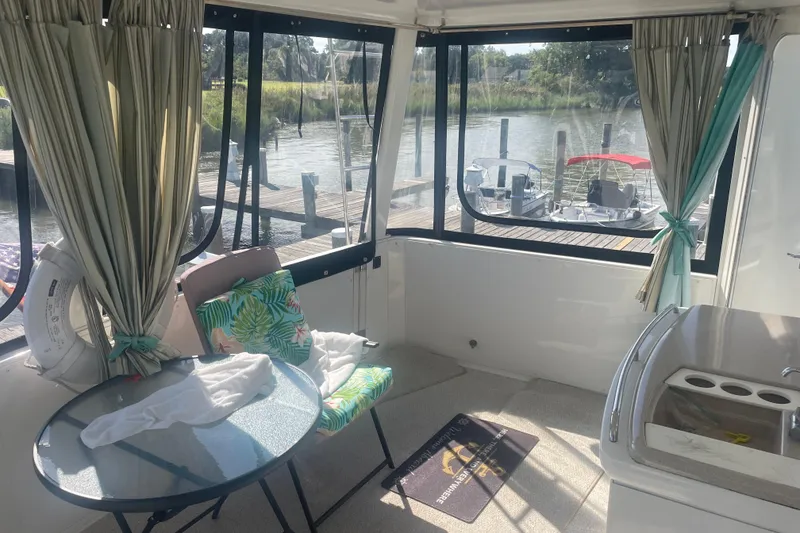 Slide: The Image of Interior of 2000 Carver 456 Aft Cabin Motor Yacht with table, chairs, and dock view. - 3