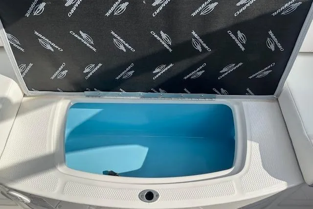 Slide: The Image of 2026 Chaparral 21 SSi boat storage compartment with open lid, featuring branded interior. - 31