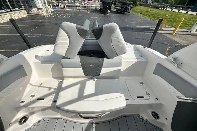 Slide: The Image of 2026 Chaparral 21 SSi boat interior with white and gray seating, docked outdoors. - 32