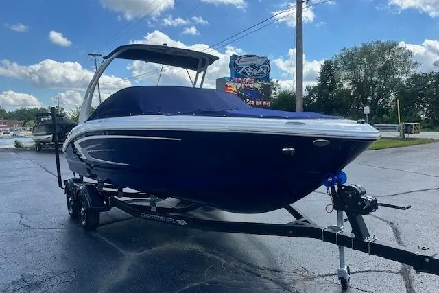 Slide: The Image of 2026 Chaparral 21 SSi boat on trailer, parked outdoors under a blue sky. - 34