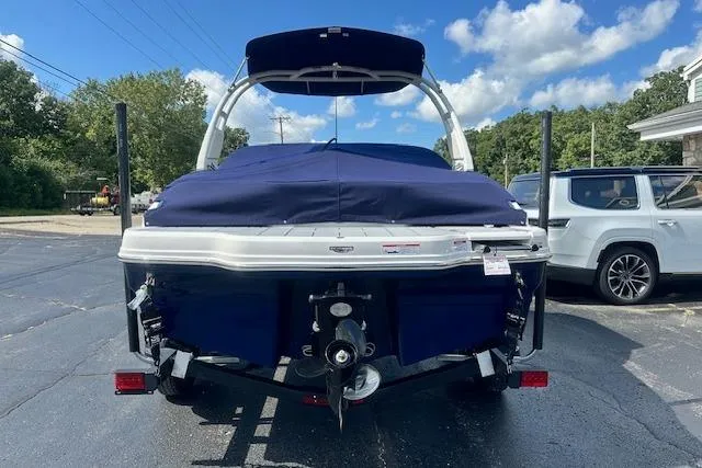 Slide: The Image of 2026 Chaparral 21 SSi boat on trailer, covered, parked outdoors under blue sky. - 37