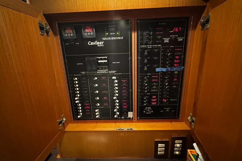 Slide: The Image of Electrical panel of a 2002 Cavileer 48 Flybridge Sportfish yacht, featuring various switches and gauges. - 12