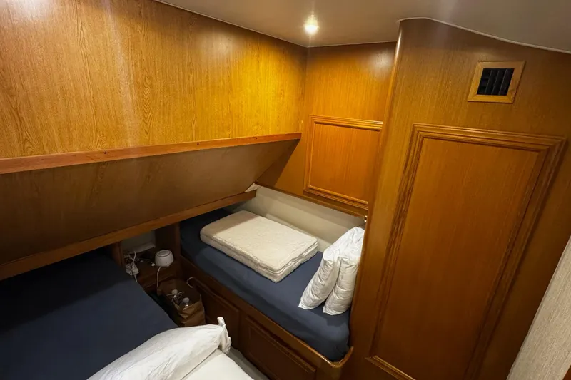 Slide: The Image of 2002 Cavileer 48 Flybridge Sportfish cabin with wooden interior and cozy bedding. - 17