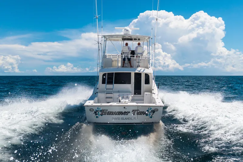 Slide: The Image of 2002 Cavileer 48 Flybridge Sportfish cruising on open ocean under clear blue sky. - 2