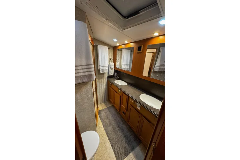 Slide: The Image of Luxurious bathroom in 2002 Cavileer 48 Flybridge Sportfish yacht with dual sinks and wooden cabinetry. - 21