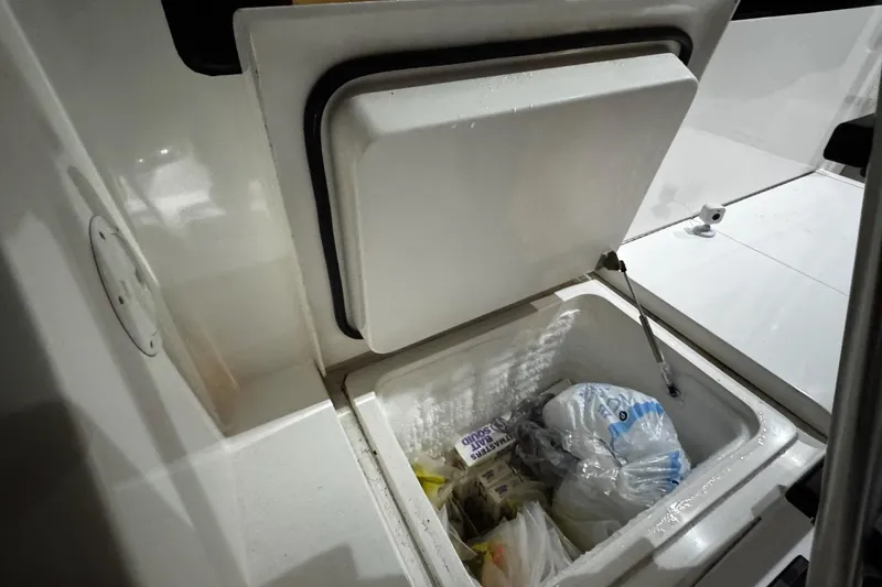 Slide: The Image of Open storage compartment on 2002 Cavileer 48 Flybridge Sportfish boat, containing various items. - 26