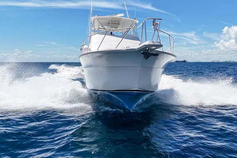 Slide: The Image of 2002 Cavileer 48 Flybridge Sportfish cruising on open ocean under clear blue sky. - 4