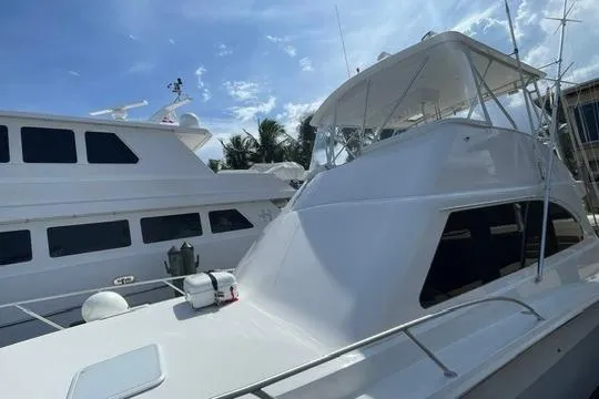 Slide: The Image of 2002 Cavileer 48 Flybridge Sportfish yacht docked under a clear blue sky. - 52