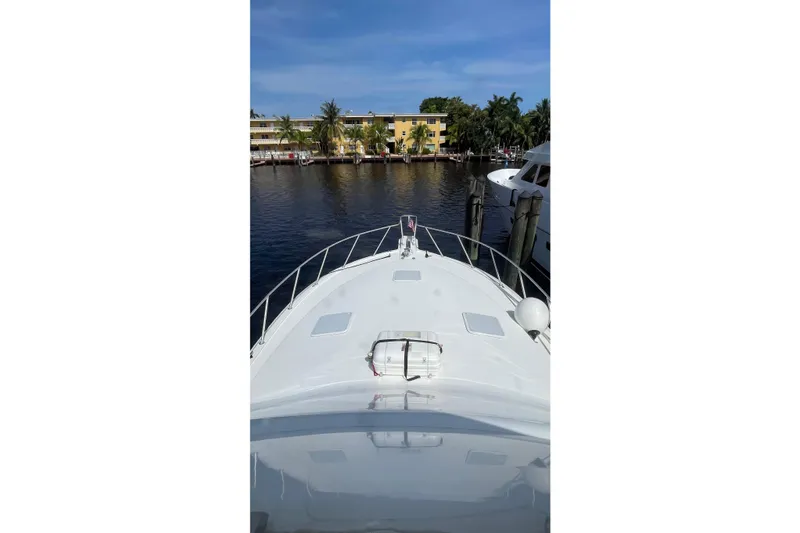 Slide: The Image of 2002 Cavileer 48 Flybridge Sportfish yacht docked by waterfront buildings. - 56