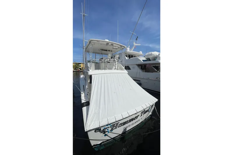 Slide: The Image of 2002 Cavileer 48 Flybridge Sportfish docked, covered stern, clear sky background. - 57