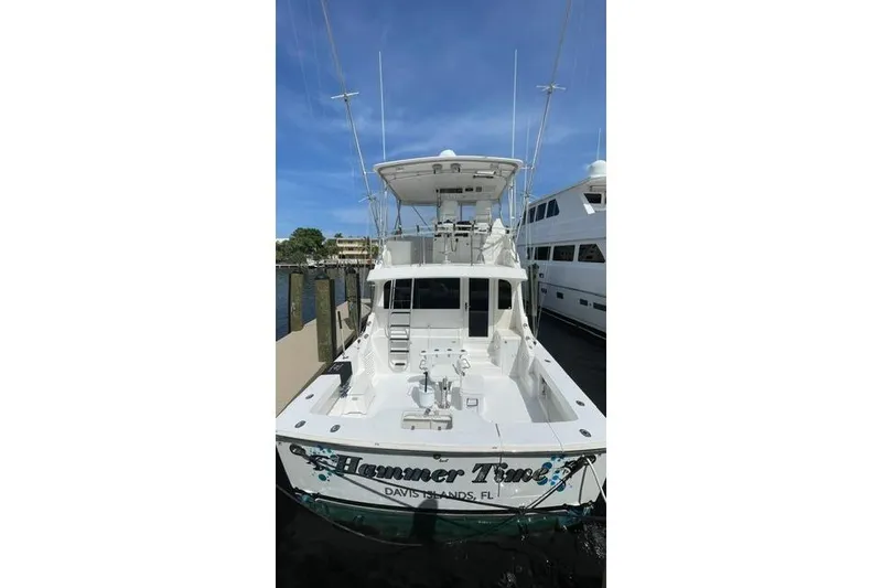 Slide: The Image of 2002 Cavileer 48 Flybridge Sportfish boat docked, rear view, clear sky background. - 59