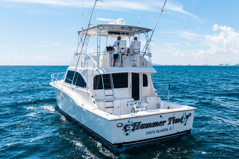 Slide: The Image of Cavileer 48 Flybridge Sportfish 2002 cruising on open sea under clear blue sky. - 60