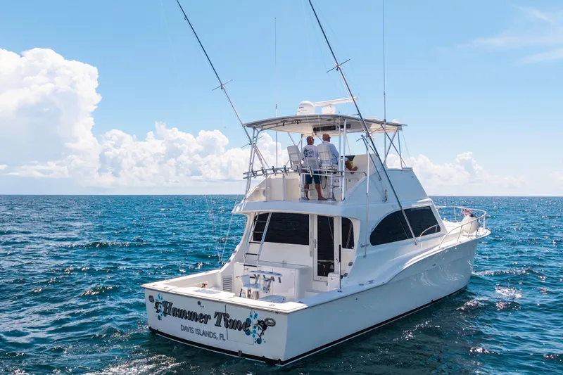 Slide: The Image of 2002 Cavileer 48 Flybridge Sportfish yacht cruising on open ocean under clear skies. - 62