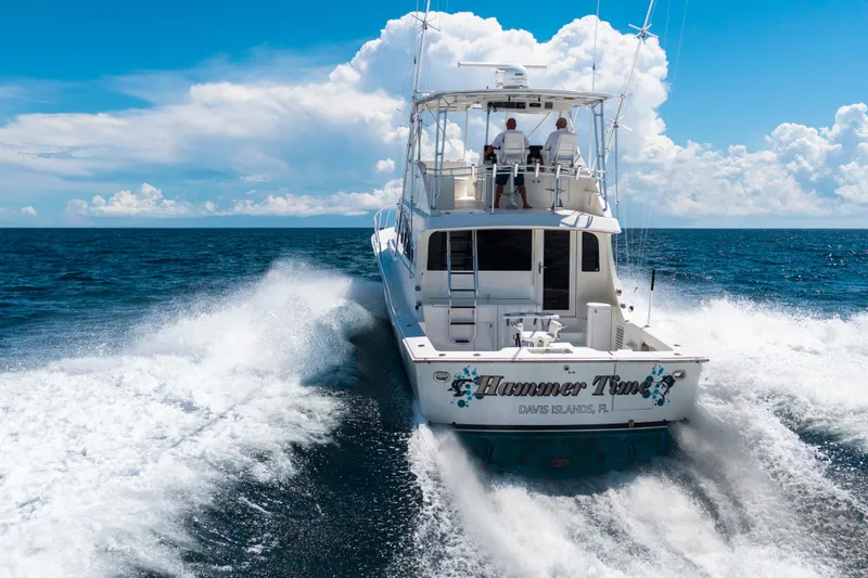 Slide: The Image of 2002 Cavileer 48 Flybridge Sportfish cruising on open ocean under clear blue sky. - 64