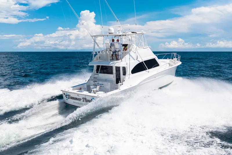 Slide: The Image of 2002 Cavileer 48 Flybridge Sportfish cruising on open ocean under clear blue sky. - 67