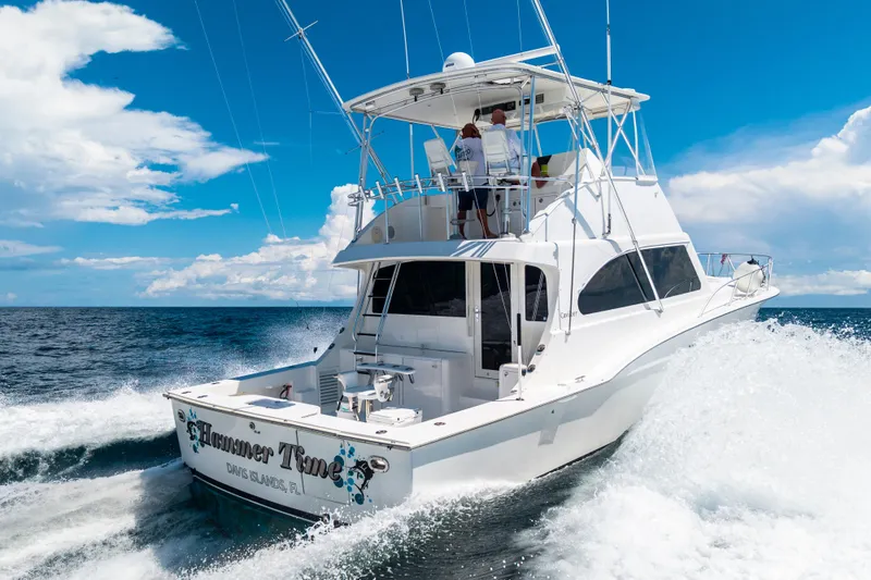 Slide: The Image of 2002 Cavileer 48 Flybridge Sportfish cruising on open ocean under clear blue sky. - 68