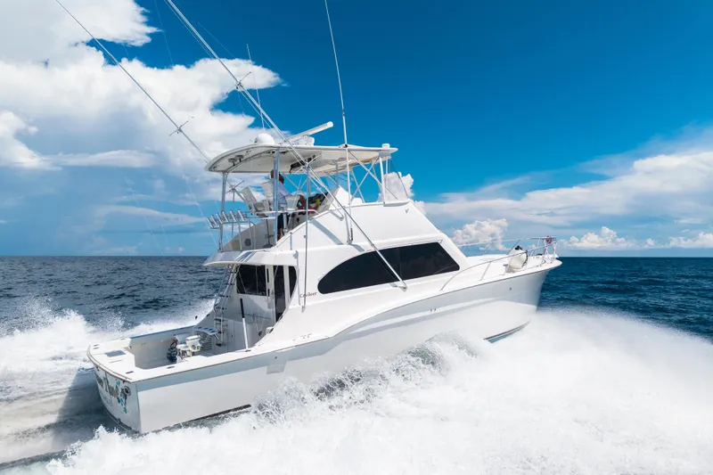 Slide: The Image of 2002 Cavileer 48 Flybridge Sportfish cruising on open ocean under clear blue sky. - 69