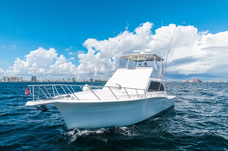 Slide: The Image of 2002 Cavileer 48 Flybridge Sportfish yacht cruising on open water under blue skies. - 72