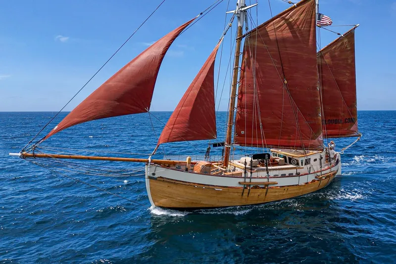 Slide: The Image of 1938 Norwegian Double Ended Ketch sailing on open sea with red sails. - 13