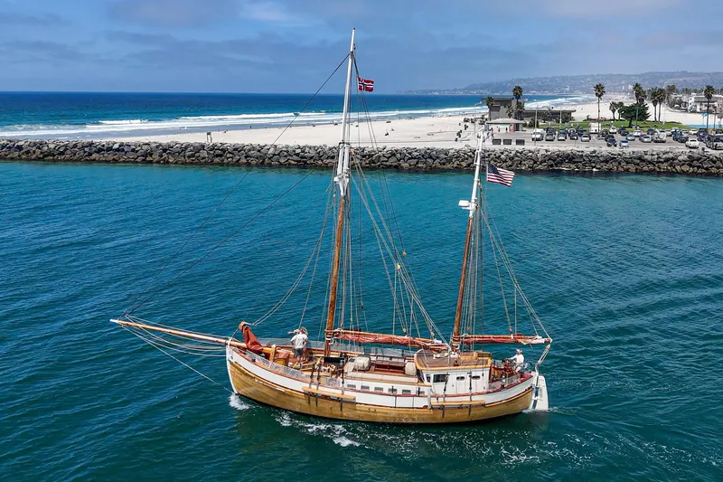 Slide: The Image of 1938 Norwegian Double Ended Ketch sailing near a scenic coastline. - 16