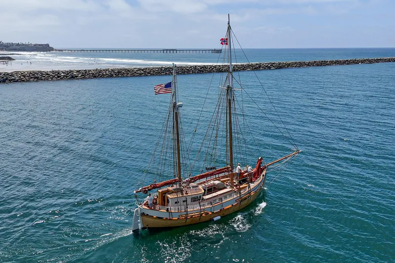 Slide: The Image of Vintage 1938 Norwegian Double Ended Ketch sailing near a coastal pier. - 18