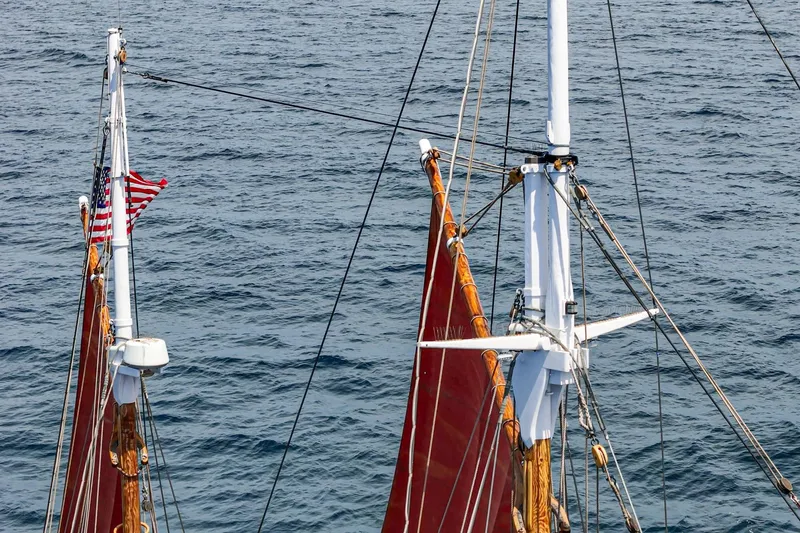 Slide: The Image of 1938 Norwegian Double Ended Ketch with red sails and American flag on open sea. - 20