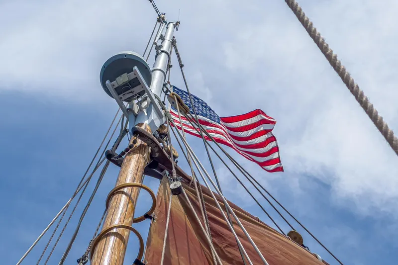 Slide: The Image of Mast of 1938 Norwegian Double Ended Ketch with American flag against blue sky. - 21