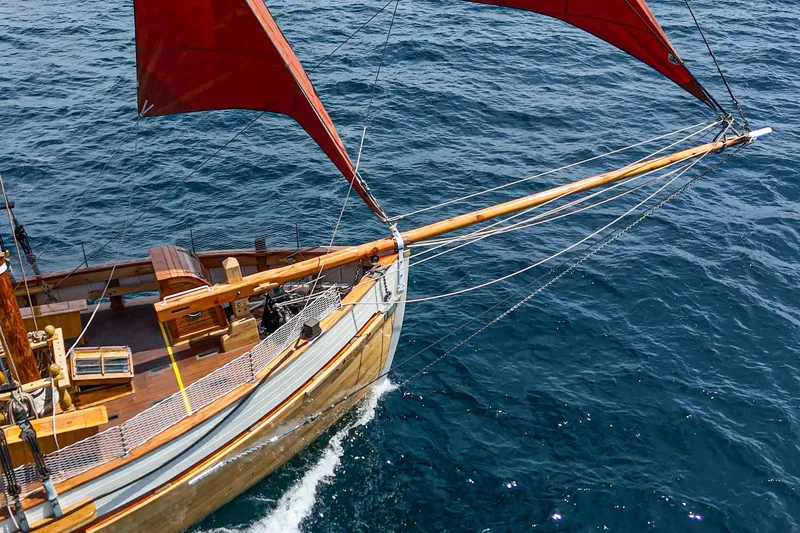 Slide: The Image of Vintage 1938 Norwegian Double Ended Ketch sailing on open sea with red sails. - 23