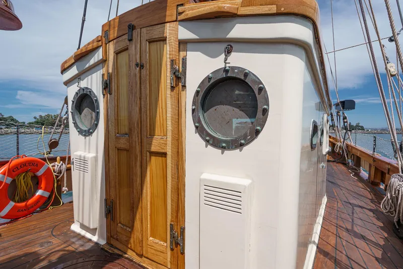 Slide: The Image of 1938 Norwegian Double Ended Ketch with wooden cabin and portholes, docked by the sea. - 51